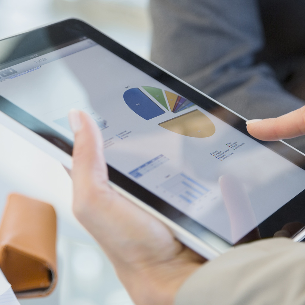 Photo of a tablet in which graphs are shown, representing the PCI DSS requirements of data security compliance