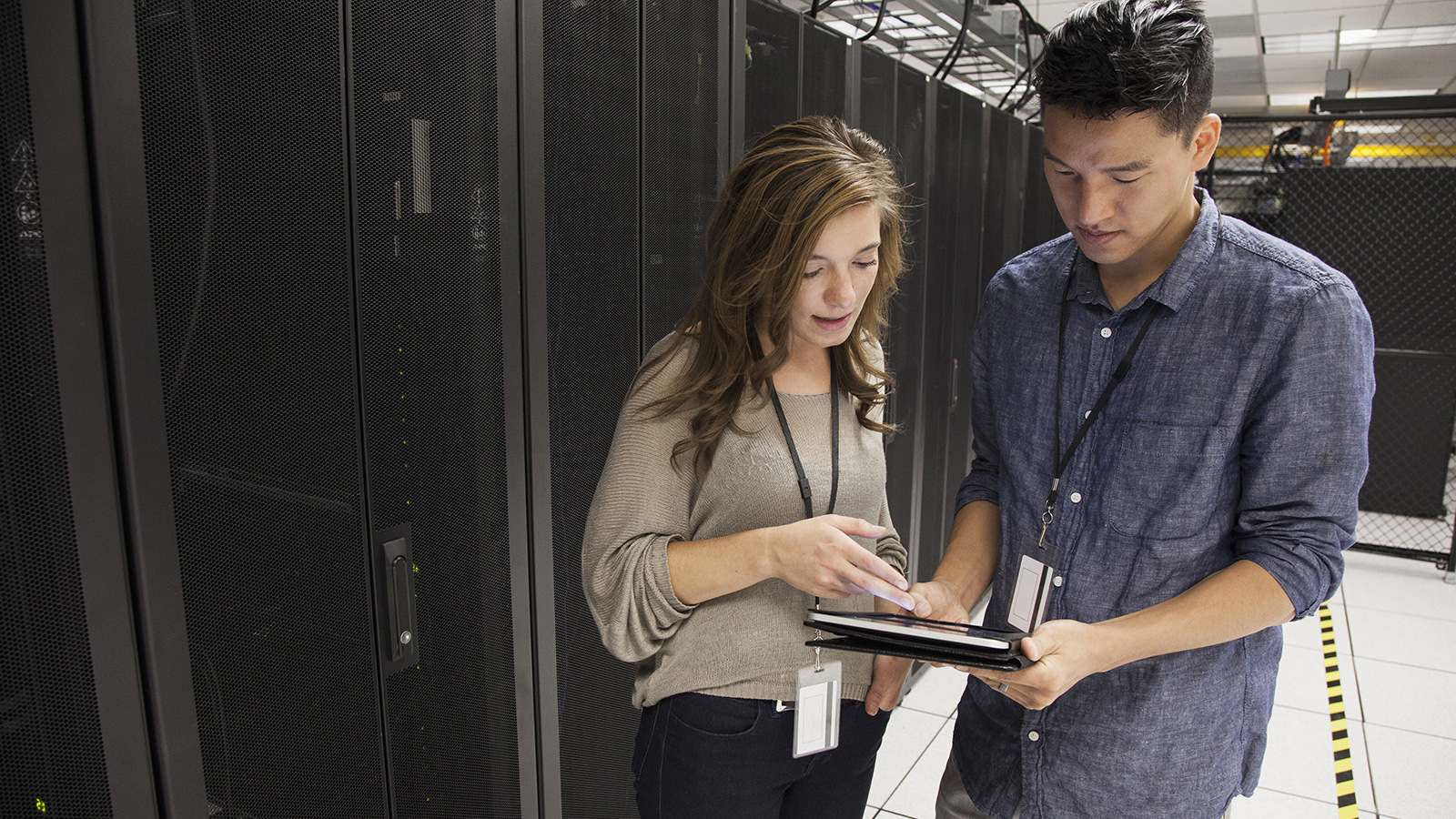 Photo of two individuals checking that they comply with PCI DSS requirements