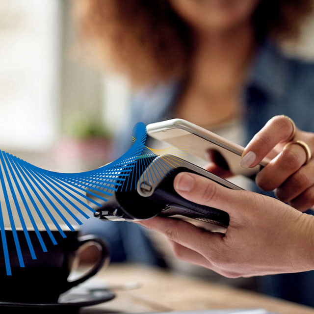 Woman paying with her mobile phone at a retailer.