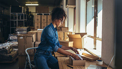 Lady unboxing an item in a storeroom