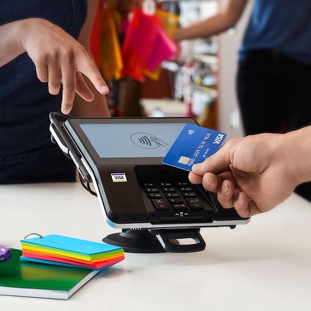 Woman pointing to contactless card reader.